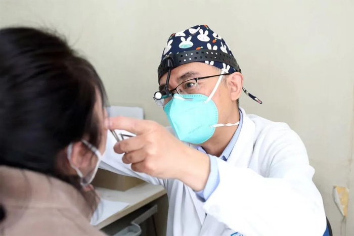 北京大学人民医院耳鼻咽喉头颈外科主任医师王旻在门诊为患者检查鼻腔。（北京大学人民医院供图）