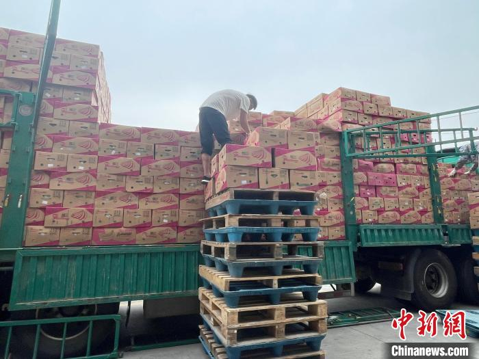  商户正在装卸货物。　卢琪 摄
