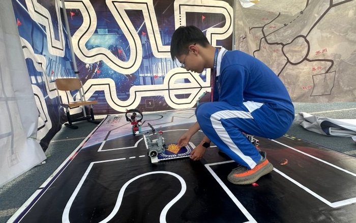 初中学生在摊位前展示轨迹机器人。 新京报记者刘洋 摄