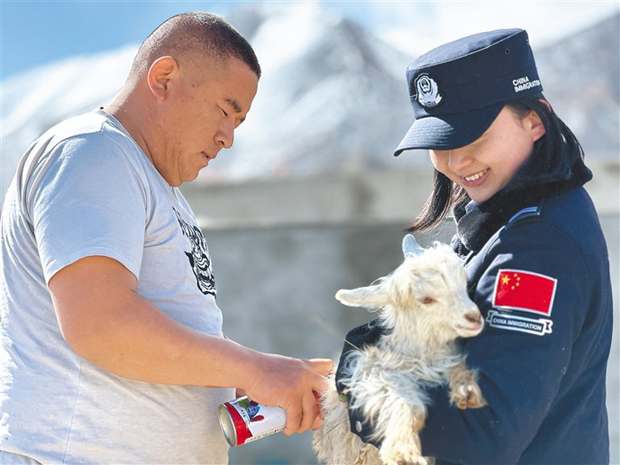 图为日土边境派出所民警李泉娴（右）帮助村民给小羊羔喷标记。记者 张宇 通讯员 任博 摄