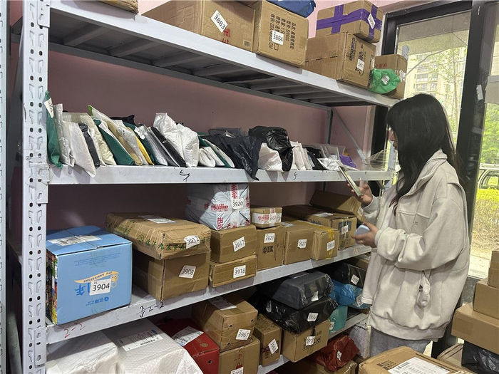 市民正在快递驿站自取快递。
