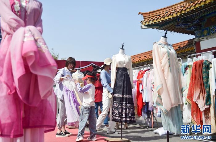   4月14日，在洛阳市中国国花园一家汉服体验馆里，游客在挑选汉服服饰。
