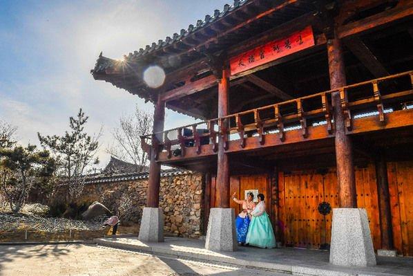 3月7日，游客在位于延吉市的中国朝鲜族民俗园身穿朝鲜族传统服饰拍照留念。 新华社记者 许畅 摄