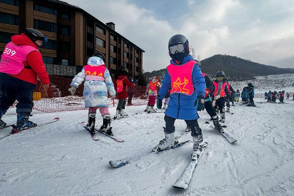 2023年12月5日，在吉林省吉林市万科松花湖度假区，小朋友们在教练的指导下练习滑雪动作。 新华社记者 许畅 摄