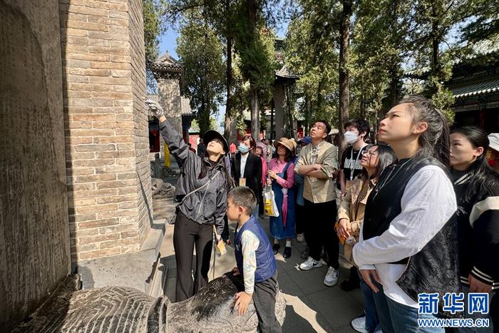 　　4月12日，在少林寺内，讲解员在讲述少林寺内石碑的来历。