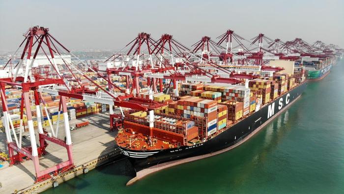 3月13日，货轮在山东港口青岛港装卸集装箱（无人机照片）。新华社记者 李紫恒 摄