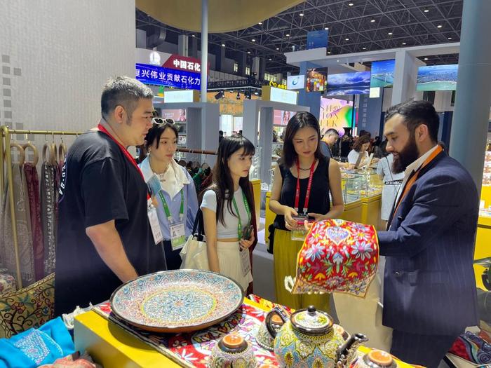 乌兹别克斯坦参展商阿森贝克正在向中国客商介绍乌兹别克斯坦产品。新华社记者程潇 摄