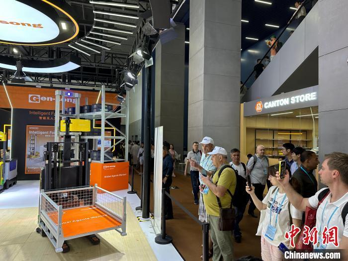 4月17日，境外采购商在第135届广交会上观看智能搬运AGV(自动导向车)展演。　中新社记者 程景伟 摄