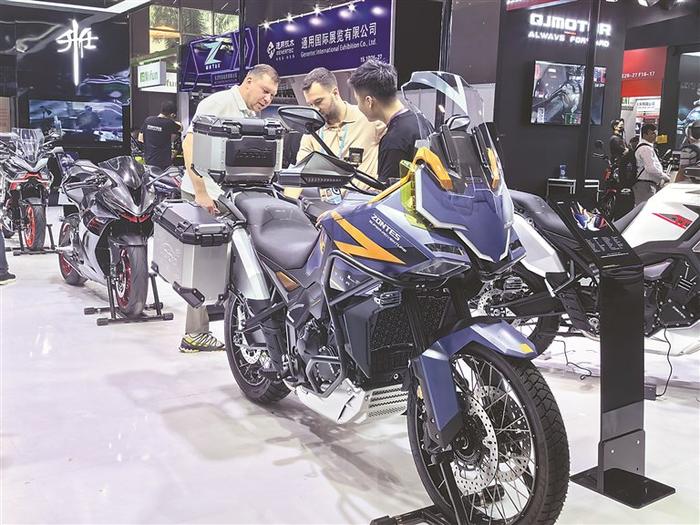 图为采购商在广交会摩托车展区咨询某企业新品车型。 记者 柴雅欣 摄