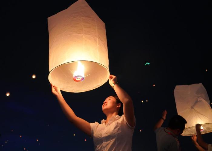 4月13日晚，人们在云南省景洪市澜沧江边放飞孔明灯。新华社记者 王静颐 摄