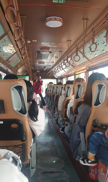 身着红衣的工作人员用随身携带的扩音器向车上的游客推销旅游商品