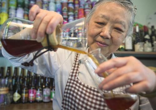 ▲雷善蓬正在将制作的手冲咖啡为客人分装。记者 张质 摄