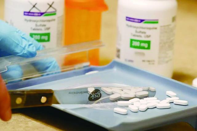 图片说明： 药物短缺在困扰越来越多的美国人。图为美国药店员工在处理药物。