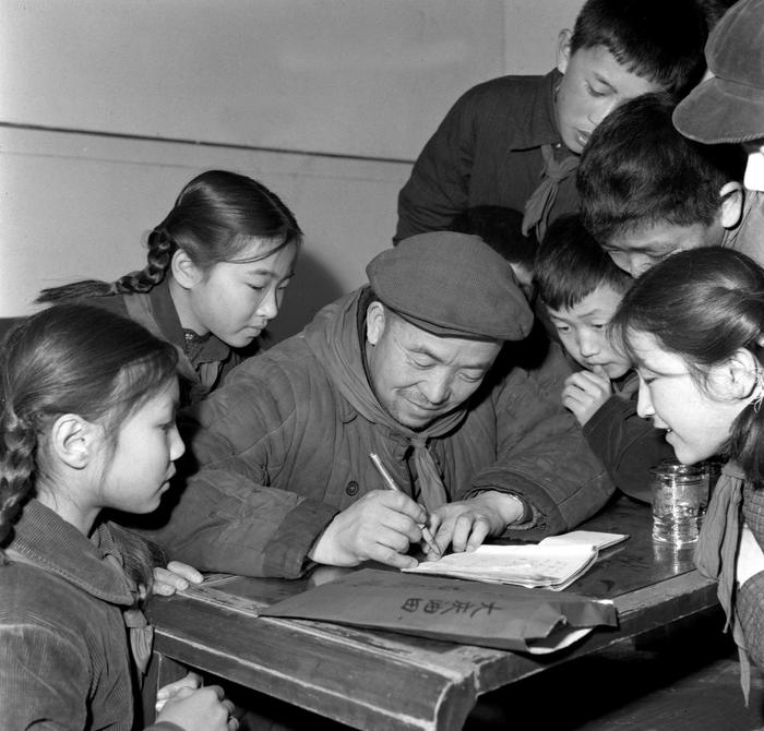 1966年，王进喜在北京少年儿童科学馆为孩子签字，勉励孩子们努力奋斗。