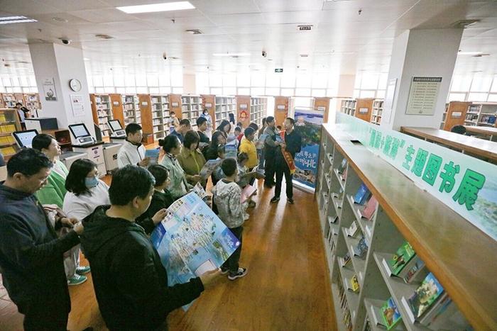4月13日，在唐山市图书馆“阅读+旅游”主题图书展展区，工作人员向读者推荐旅游相关书籍。 河北日报记者 王育民摄