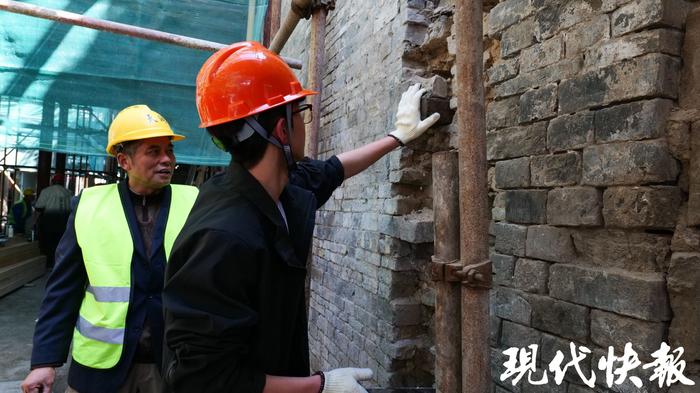 大学生在师傅的带领下为古建筑修墙