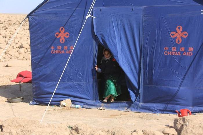 2023年10月16日，在阿富汗西北部赫拉特省津达詹地区，儿童站在中国援助的帐篷门口。新华社发（塞夫拉赫曼·萨菲摄）
