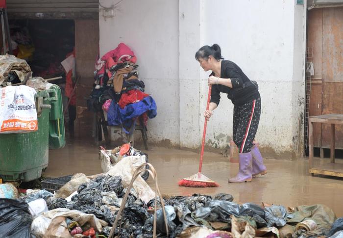 4月21日，洪水过后，广东省韶关市武江区龙归镇的居民在清理路面。新华社记者 卢汉欣 摄