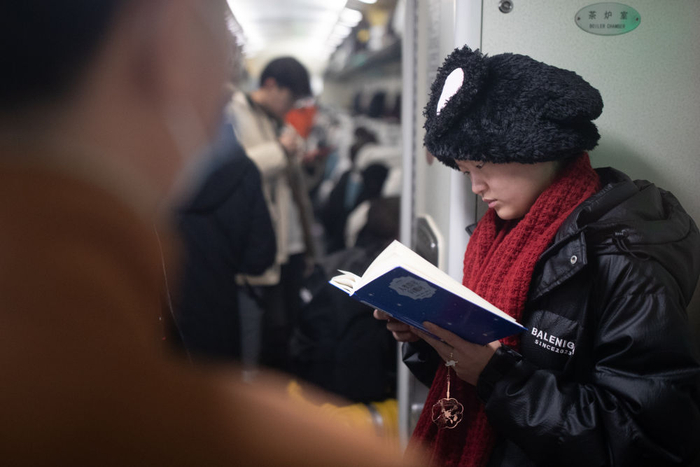 2024年1月30日，一位旅客在由哈尔滨开往漠河的K7041次列车内阅读书籍。