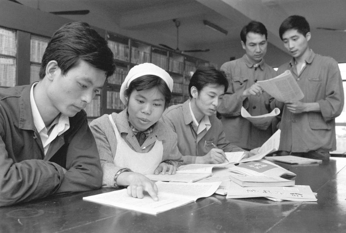1982年，原上海第一棉纺织厂南纺工场理论学习班的青年工人在认真阅读有关社会主义经济发展的文章。