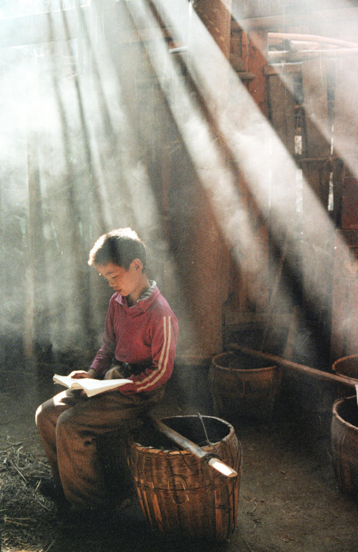 1990年，在贵州省松桃苗族自治县，一位小朋友正在读书。