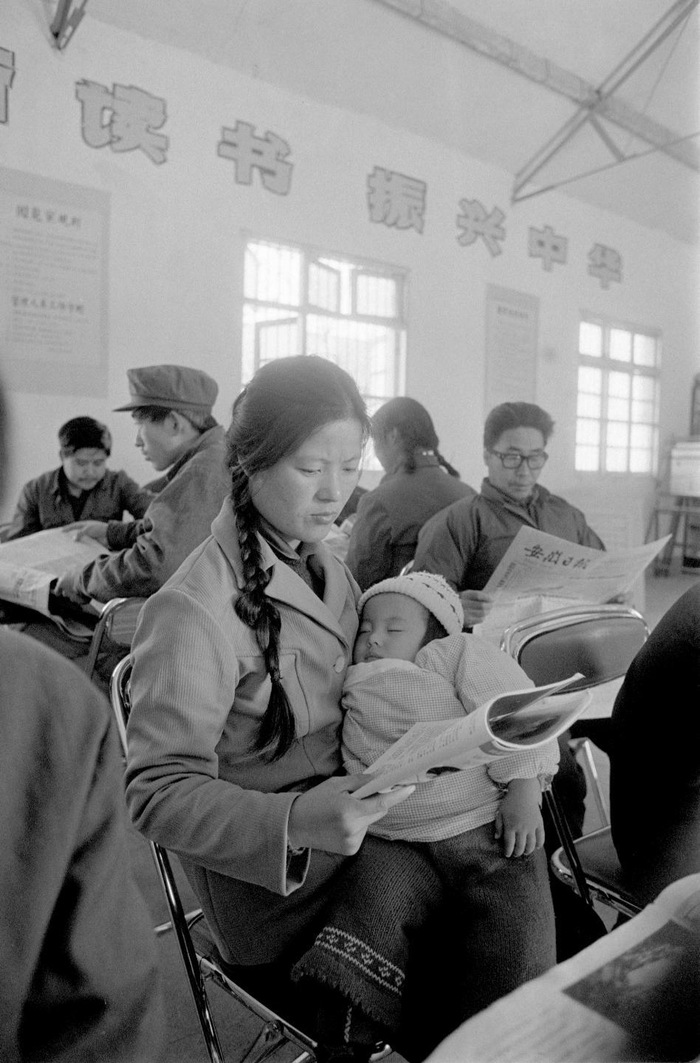 1984年，在安徽天长郑集公社（现郑集镇）文化中心图书阅览室内，一位母亲抱着熟睡的孩子在阅读。