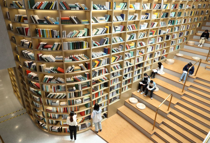 2021年5月2日，读者在安徽省蒙城县图书馆天梯书架旁阅读书籍。