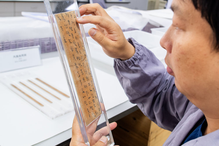  2023年5月20日，在荆州文保中心，修复人员查看修复完成的简牍。新华社记者 肖艺九 摄