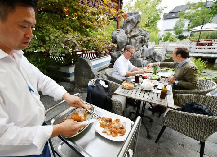 2023年9月28日，德国汉堡豫园餐厅工作人员为顾客片烤鸭。（任鹏飞 摄）