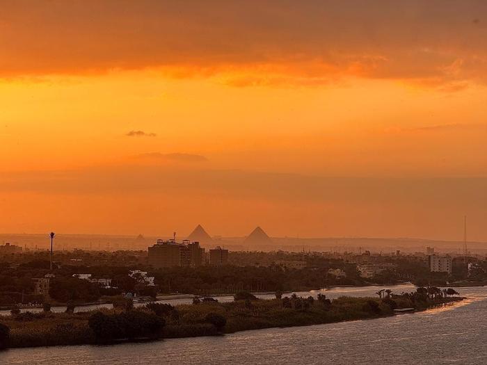 这是1月27日在埃及首都开罗拍摄的尼罗河上的晚霞，远处是吉萨大金字塔。新华社记者王东震摄