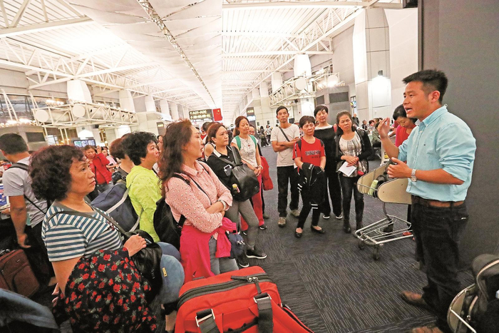     导游为出境游客介绍海关安检注意事项           本报记者 陈晨 摄