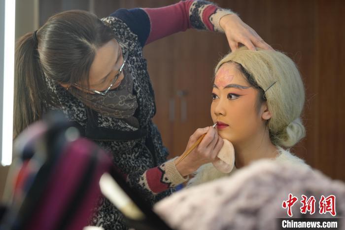 近日，化妆师为桂剧演员朱明娟上妆。　(受访者供图)