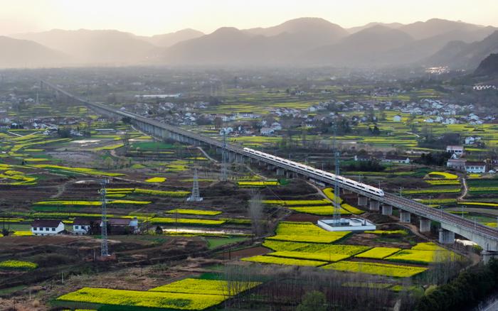   2024年3月20日，西成高铁线上的列车驶过陕西汉中市南郑区阳春镇（无人机照片）。新华社记者邵瑞摄
