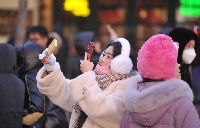 哈尔滨中央大街游人如织，冰雪旅游热度持续