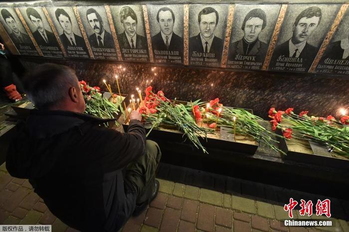 图为2019年，当地时间4月26日，乌克兰民众凌晨前往墓地，点烛献上鲜花悼念在清理切尔诺贝利核事故中死亡的“清理人”。