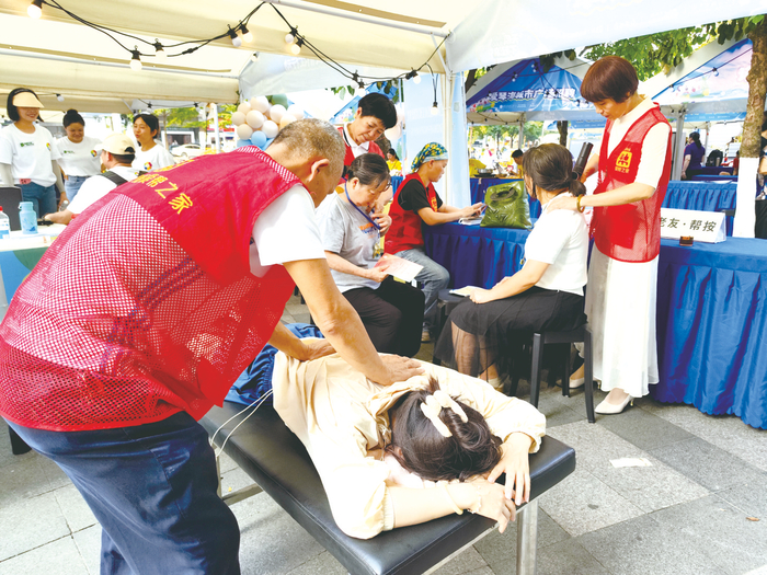     ▲志愿者在为居民提供按摩服务    本报记者    刘增璇 摄