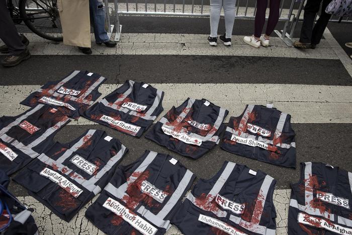 ▲抗议者展示在加沙遇害记者的新闻背心。图据视觉中国