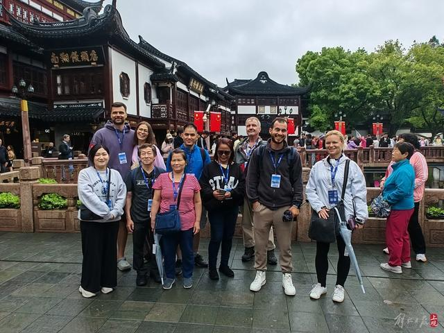 今天参团免费半日游的国际游客在九曲桥前留影。 李宝花 摄