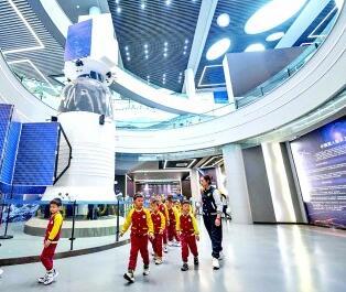 哈尔滨工业大学航天馆，小朋友在神舟五号载人飞船（1∶1模型）前参观。新华社发