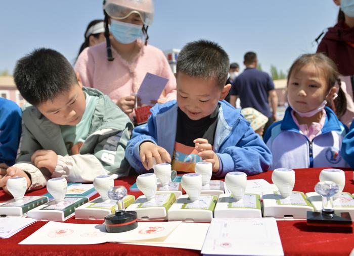 4月26日，小朋友们在东风航天城东风礼堂前组织的主题活动上打卡盖章。