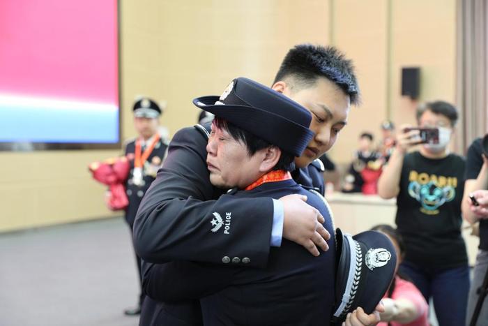 4月26日，民警包牧仁在警号传承仪式上拥抱母亲索连红。