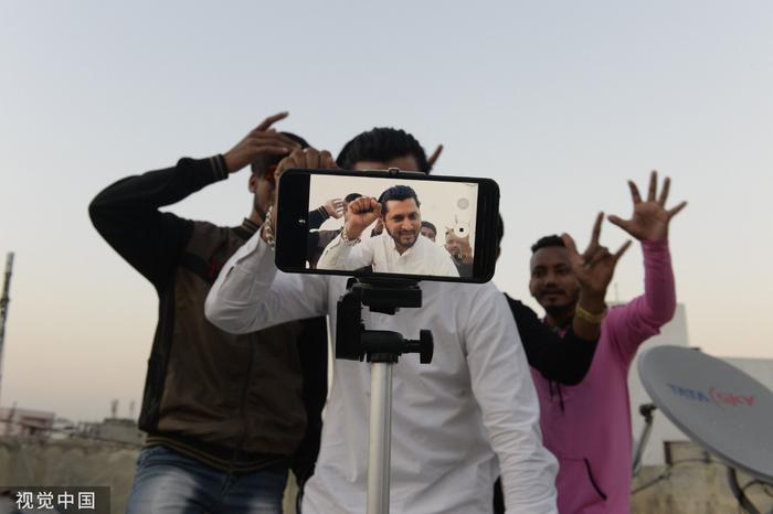 当地时间2020年2月14日，印度海得拉巴，一群年轻人在自家阳台上拍摄TikTok视频。