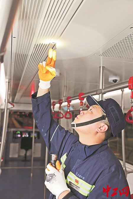 深夜，刘忠飞在检查地铁车厢空调出风口。工人日报-中工网记者 李彦斌 摄