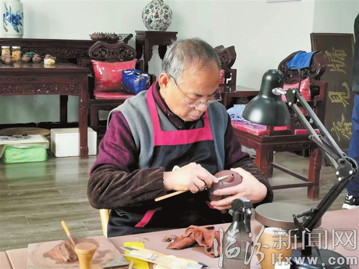 图为吴志文正在制作紫砂陶产品