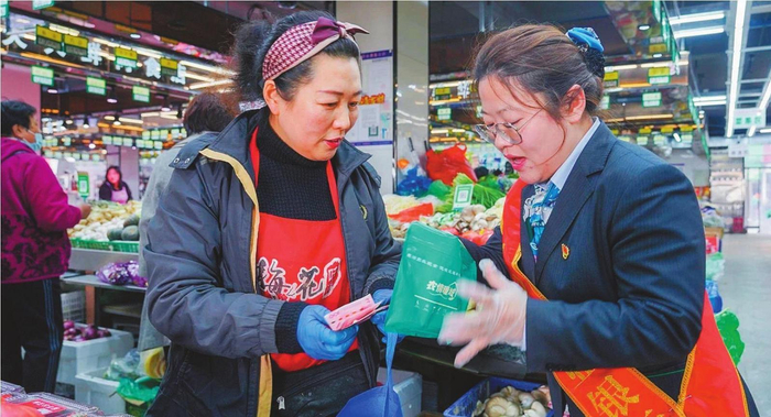         农行大连市分行网点员工为超市商户提供“零钱包”兑换业务。张学峰  摄