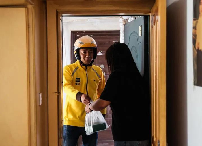美团平台长春红旗街配送站站长王文思为客户提供服务。新华社记者 王帆 摄
