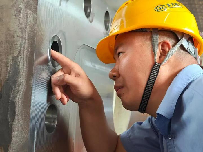 刘闯用手感知一个关键部件。新华社记者 谢佼 摄
