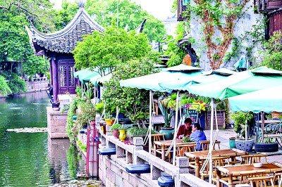 游客在浙江嘉兴月河历史街区河边喝茶休息。新华社发