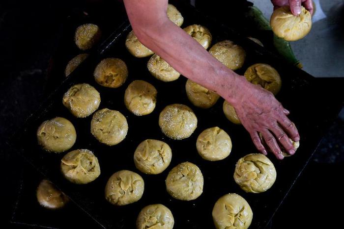   月饼制作人将捏好的月饼面团放在烤盘中（资料照片）。新华社记者 刘磊 摄