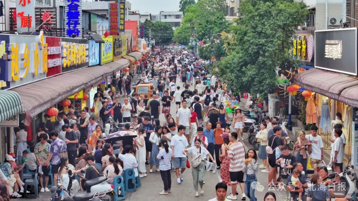 众多游客来侨港风情街品尝美食。许振国 摄